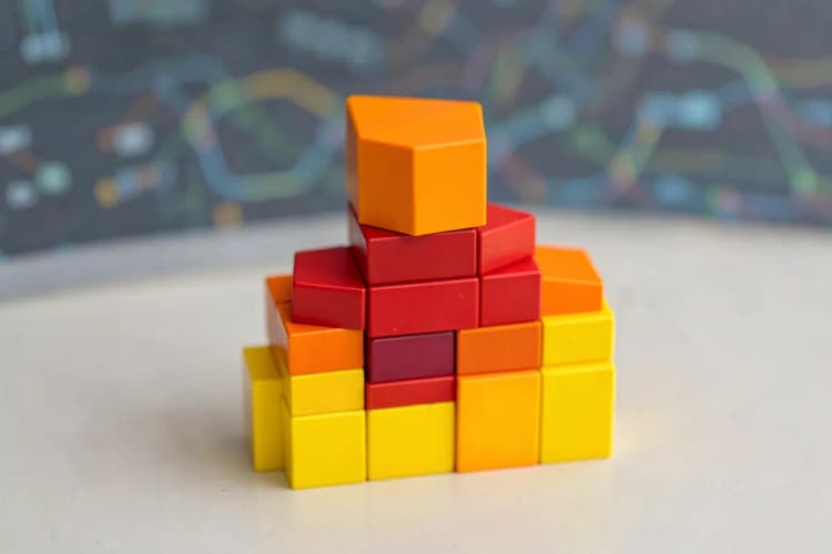 Um conjunto de blocos de construção coloridos empilhados em ordem crescente, com um fundo desfocado de linhas de dados digitais