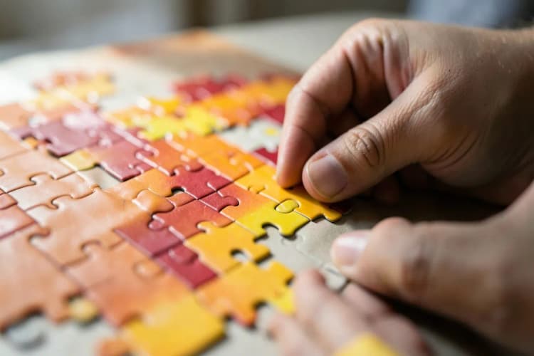 Uma pessoa montando um quebra-cabeça com peças coloridas, representando a montagem de um anúncio eficaz.