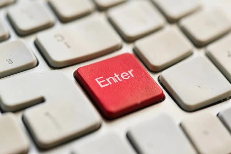 Um close-up de um teclado de computador com a tecla 'Enter' em destaque.