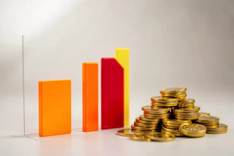 Gráfico de barras ascendente com moedas de ouro ao lado, simbolizando crescimento financeiro.